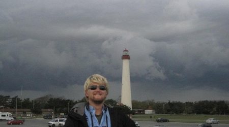 Tom Johnson atop the Cape May Hawkwatch platform, with the iconic Cape May lighthouse in the background © Tom Johnson